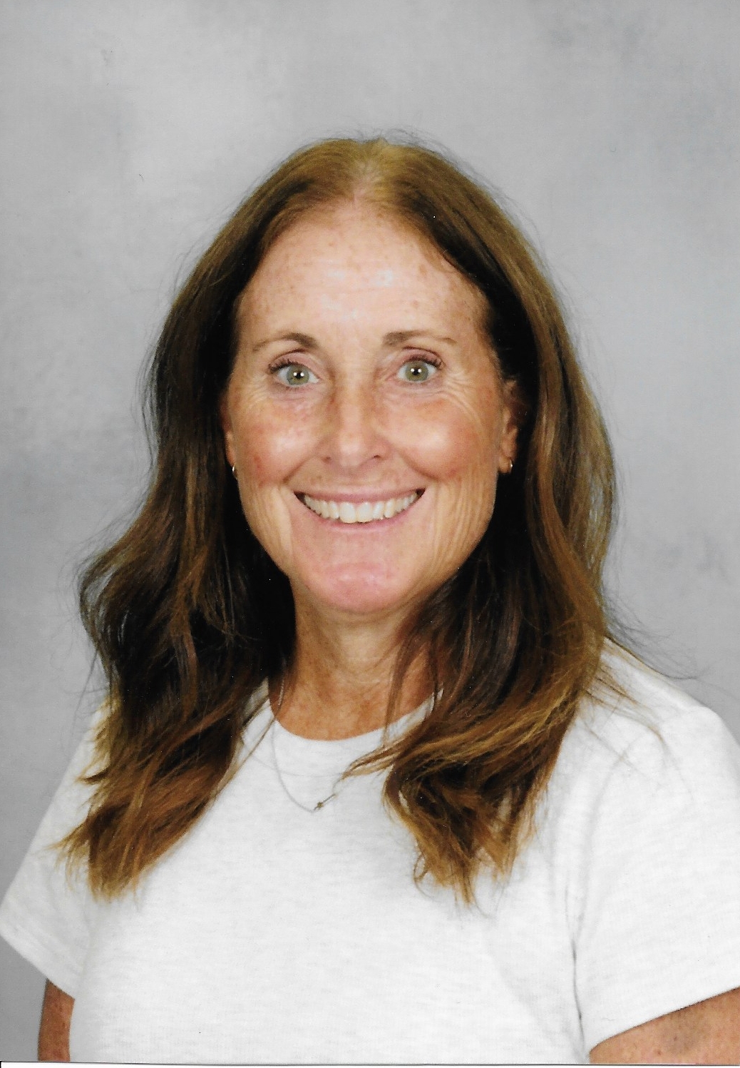 A woman faces the camera in a portrait photo against a neutral background