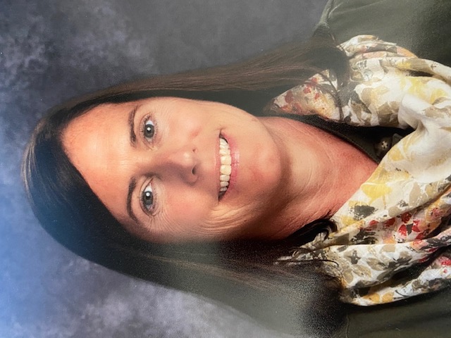 A woman faces the camera in a formal portrait photo