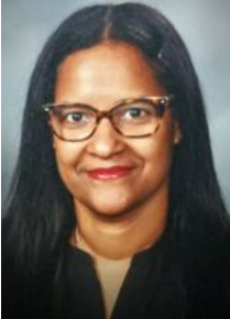 A woman with glasses looks directly at the camera in a formal portrait