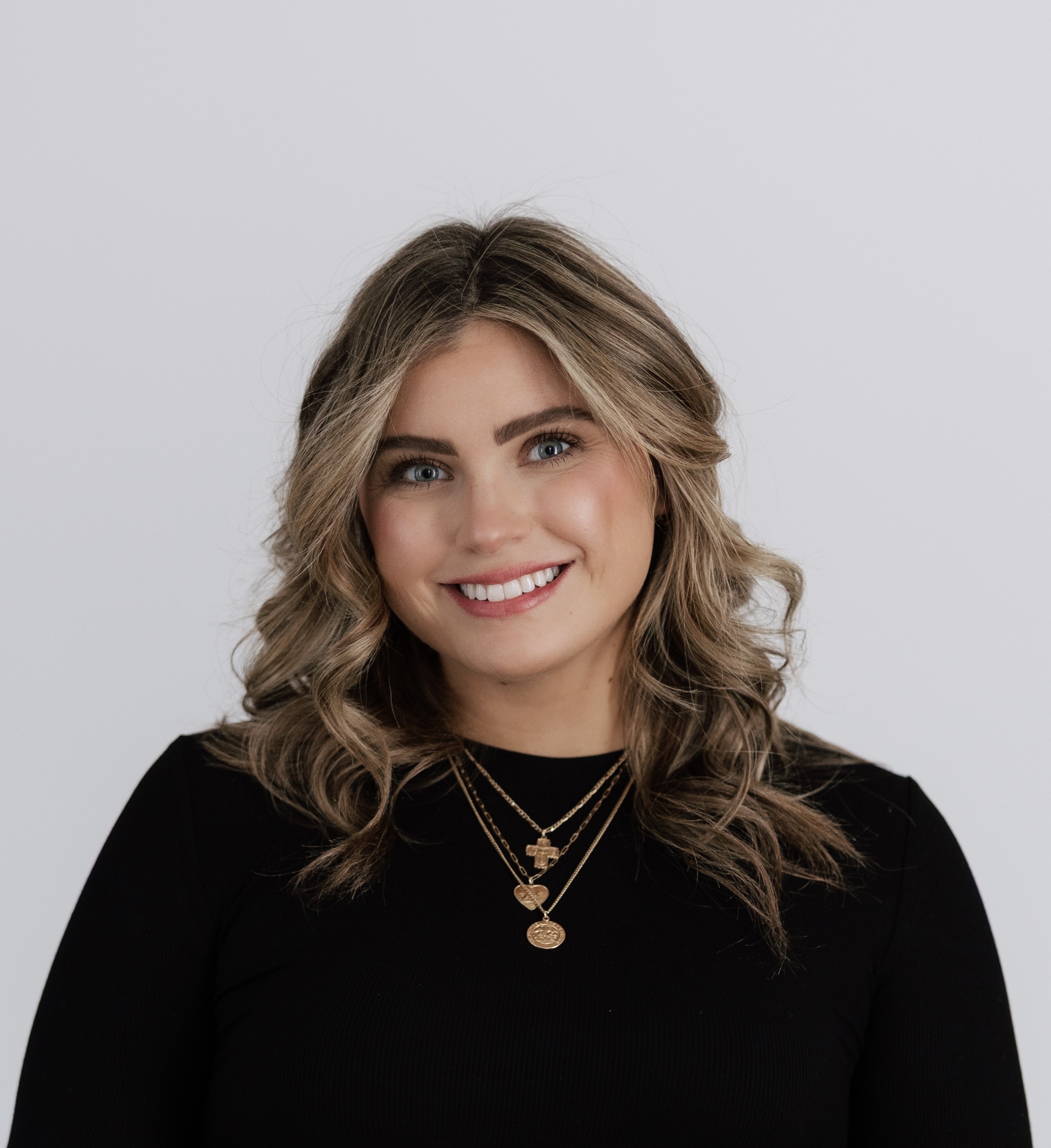 A woman faces the camera in a professional headshot portrait