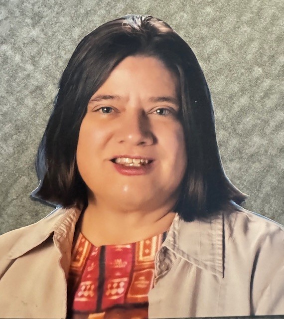 A close-up portrait of a woman with shoulder-length dark hair